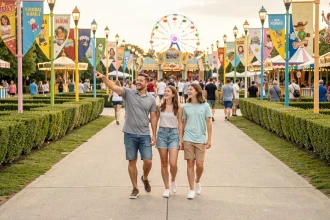 Famille se promenant dans un parc d'attractions coloré lors d'une visite en été